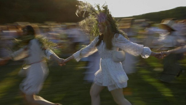 People dance around a campfire during the Ivana Kupala holiday celebration, an ancient tradition with roots in pagan times, amid Russia's attack on Ukraine, at the National Museum of Folk Architecture and Life of Ukraine, in Kyiv, Ukraine, June 21, 2