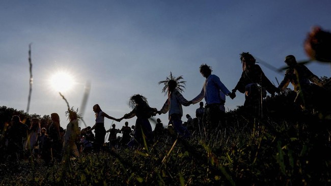 People dance around a campfire during the Ivana Kupala holiday celebration, an ancient tradition with roots in pagan times, amid Russia's attack on Ukraine, at the National Museum of Folk Architecture and Life of Ukraine, in Kyiv, Ukraine, June 21, 2