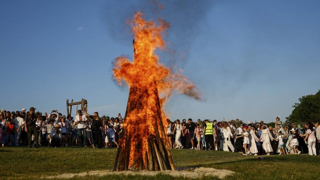 People gather to dance around a campfire during the Ivana Kupala holiday celebration, an ancient tradition with roots in pagan times, amid Russia's attack on Ukraine, at the National Museum of Folk Architecture and Life of Ukraine, in Kyiv, Ukraine,