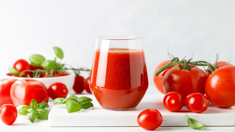 Tomato juice in a glass and fresh tomatoes
