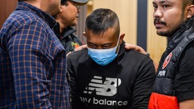 Petugas menggiring tersangka kasus dugaan penyekapan dan penganiayaan berat Taufik Hidayat (tengah) setibanya di Polda Jabar, Bandung, Jawa Barat, Selasa (23/6/2026). Polda Jabar menangkap Taufik Hidayat yang berstatus daftar pencarian orang di Kawas