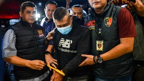 Petugas menggiring tersangka kasus dugaan penyekapan dan penganiayaan berat Taufik Hidayat (tengah) setibanya di Polda Jabar, Bandung, Jawa Barat, Selasa (23/6/2026). Polda Jabar menangkap Taufik Hidayat yang berstatus daftar pencarian orang di Kawas