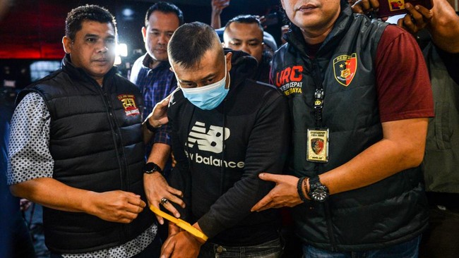 Petugas menggiring tersangka kasus dugaan penyekapan dan penganiayaan berat Taufik Hidayat (tengah) setibanya di Polda Jabar, Bandung, Jawa Barat, Selasa (23/6/2026). Polda Jabar menangkap Taufik Hidayat yang berstatus daftar pencarian orang di Kawas