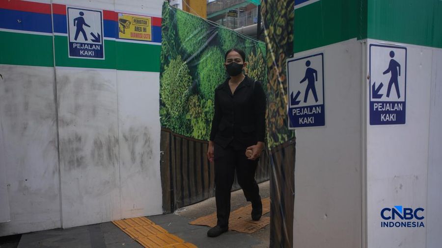 Warga melangkah kaki melewati trotoar darurat nan didekorasi menyerupai lorong taman labirin di atas area proyek pengembangan area Stasiun MRT Bundaran Hotel Indonesia, Jakarta, Rabu (24/6/2026).