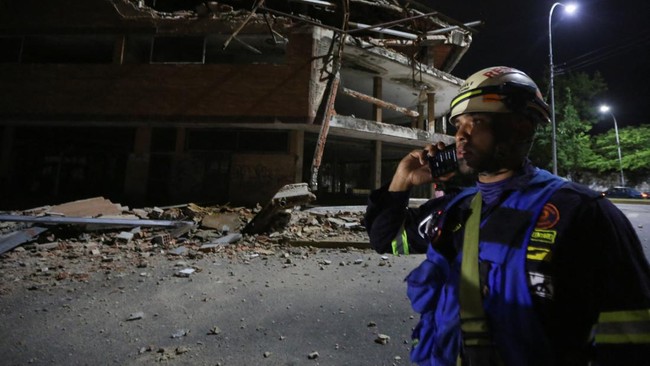 A firefighter stands next to a damaged building that used to house a university several years ago, after a strong earthquake, in Valencia, Venezuela, June 24, 2026. REUTERS/Juan Carlos Hernandez
