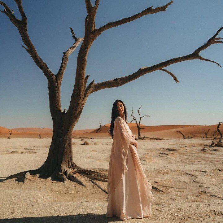 <p>Di beberapa foto <em>maternity</em> ini, Nadia banyak menunjukkan pose saat ia memamerkan <em>baby bump</em> kehamilannya yang sudah cukup besar. Dalam satu foto, perempuan 38 tahun ini tampak memegang perutnya sambil berpose di dekat pohon-pohon<em> camel thorn</em> yang ikonik di Namibia.&nbsp;(Foto: Instagram @nadsap)</p>
