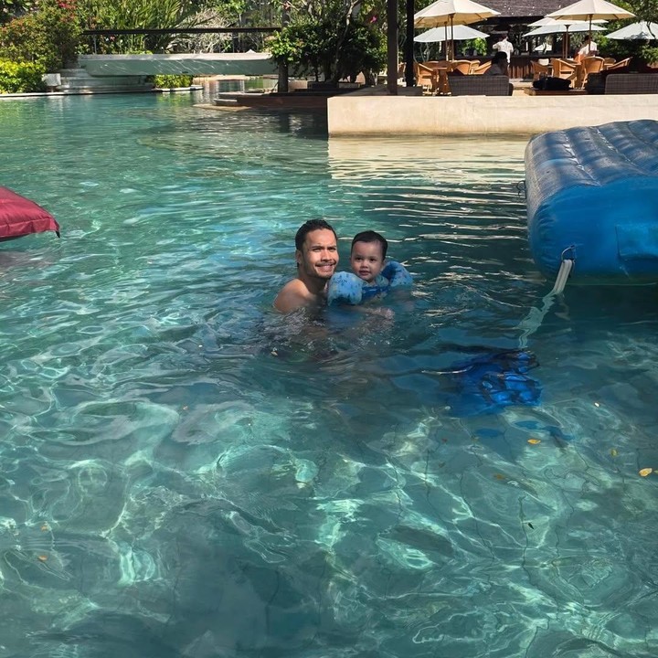 <p>Selain ke pantai, Randy juga mengajak anak-anaknya berenang di resort. Dalam satu foto yang dibagikan di Instagram, bintang film <em>Qodrat</em> ini menunjukkan momen saat mendampingi anak bungsunya Asher berenang. (Foto: Instagram @randpunk)</p>