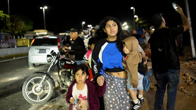A woman walks with kids after an earthquake, in Caracas, Venezuela, June 24, 2026. REUTERS/Maxwell Briceno     TPX IMAGES OF THE DAY