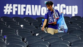 Soccer Football - FIFA World Cup 2026 - Group F - Japan v Sweden - Dallas Stadium, Arlington, Texas, U.S. - June 25, 2026 A Japan fan cleans up rubbish in the stands after the match REUTERS/Issei Kato