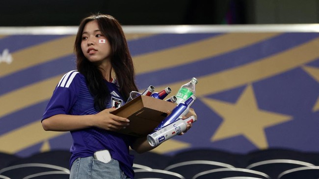 A Japanese fan cleans the stands at the end of the 2026 World Cup Group F football match between Japan and Sweden at the Dallas Stadium in Arlington on June 25, 2026.  (Photo by Aric Becker / AFP)