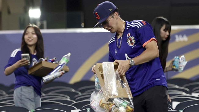Japanese fans clean the stands at the end of the 2026 World Cup Group F football match between Japan and Sweden at the Dallas Stadium in Arlington on June 25, 2026.  (Photo by Aric Becker / AFP)