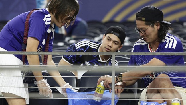 Japanese fans clean the stands at the end of the 2026 World Cup Group F football match between Japan and Sweden at the Dallas Stadium in Arlington on June 25, 2026.  (Photo by Aric Becker / AFP)