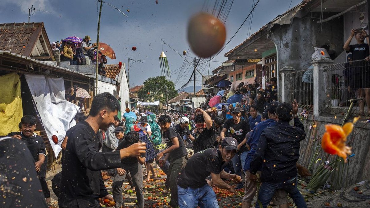 Warga saling lempar tomat busuk di Festival Perang Tomat 2026 di Kampung Cikareumbi, Lembang, Kabupaten Bandung Barat, Jawa Barat, Jumat (26/6).