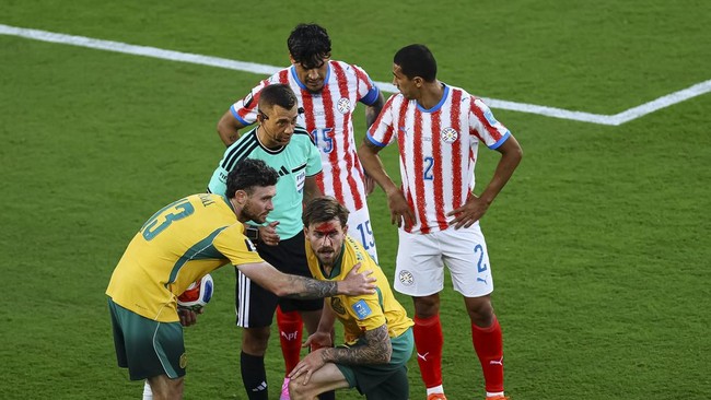 Soccer Football - FIFA World Cup 2026 - Group D - Paraguay v Australia - San Francisco Bay Area Stadium, Santa Clara, California, U.S. - June 25, 2026
Australia's Connor Metcalfe sustains an injury as Paraguay's Gustavo Gomez and Gustavo Velazquez,