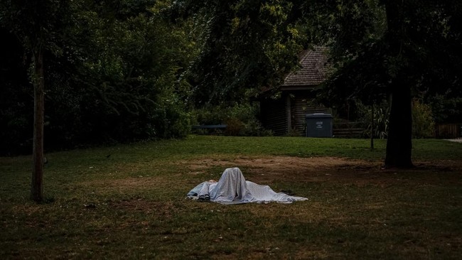 People have a rest on the grass seeking shelter from the heat in the Parc des Buttes-Chaumont in Paris, early June 26, 2026, as France experiences a heatwave. Hundreds of Parisians seeking relief from the heat took refuge in the Parc des Buttes-Chaum