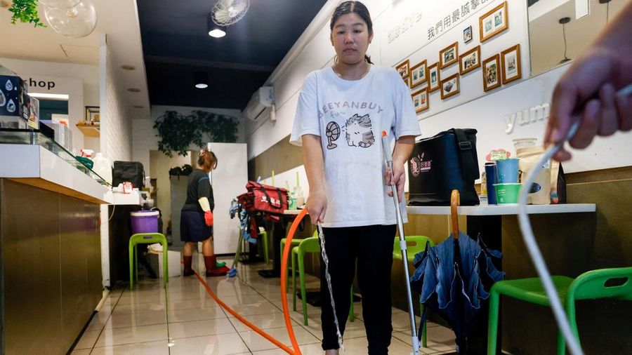 Pemilik restoran dan staf membersihkan toko mereka nan terendam banjir setelah hujan lebat nan dibawa oleh Badai Tropis Mekkhala menyebabkan banjir di Hsinchu, Taiwan, 26 Juni 2026.