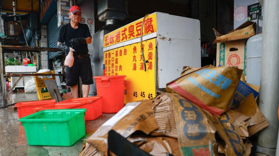 Seorang pemilik restoran membersihkan toko nan terendam banjir setelah hujan deras akibat Badai Tropis Mekkhala menyebabkan banjir di Hsinchu, Taiwan, 26 Juni 2026.