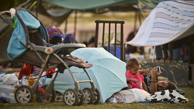 People rest in a community baseball field in the aftermath of earthquakes in La Guaira, Venezuela, June 25, 2026. REUTERS/Maxwell Briceno
