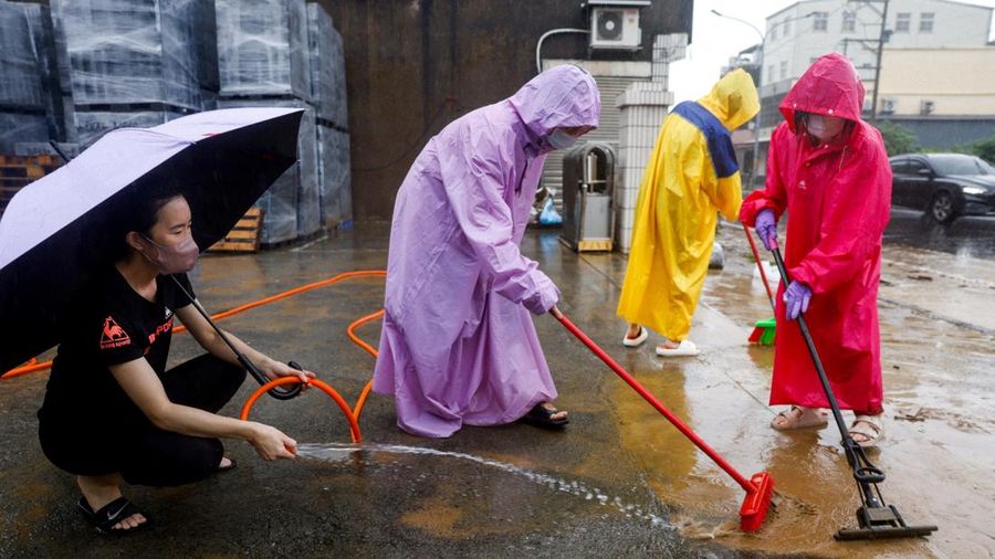 Warga membersihkan lumpur dan puing-puing dari wilayah nan tergenang banjir setelah hujan deras akibat Badai Tropis Mekkhala di Hsinchu, Taiwan, 26 Juni 2026. (REUTERS/Ann Wang)