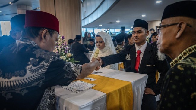 Pasangan pengantin mengikuti prosesi nikah massal pada Nikah Fest 2026 di Jakarta, Sabtu (27/6/2026). Kementerian Agama (Kemenag) menggelar program nikah massal yang diikuti 30 pasangan dari berbagai daerah di Indonesia sebagai upaya memberikan legal