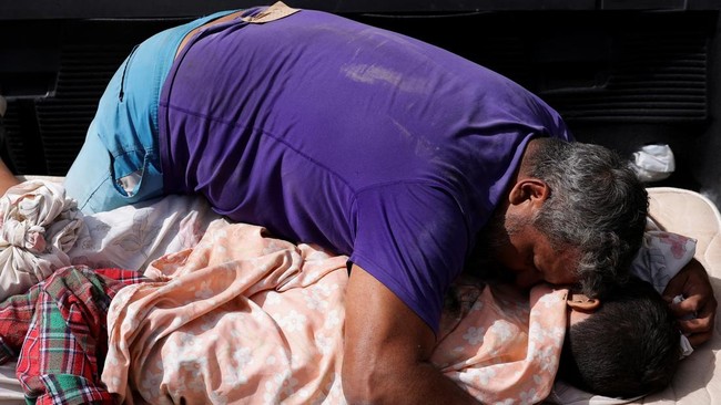 A man embraces the bodies of two children after earthquakes hit the country, in La Guaira, Venezuela, June 25, 2026. REUTERS/Gaby Oraa