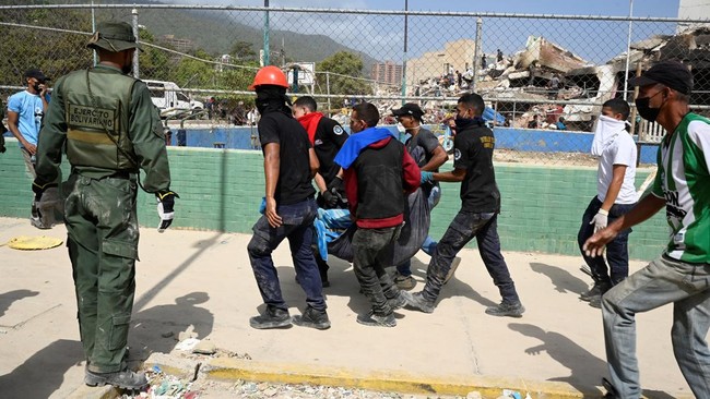 People carry a dead body after earthquakes hit the country, in La Guaira, Venezuela, June 26, 2026.