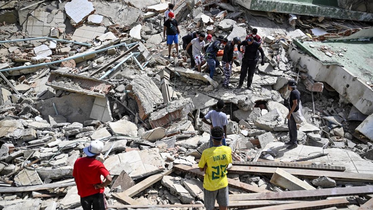Venezuelan Civil Protection members and volunteers recover a body at the site of collapsed buildings following earthquakes in Caraballeda, Venezuela.
