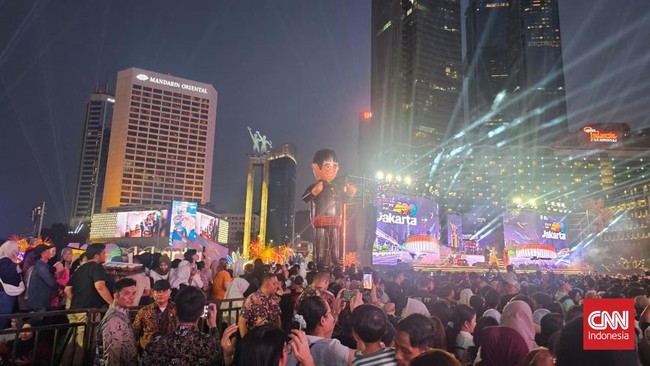 Ribuan warga memadati Bundaran HI untuk merayakan HUT ke-499 DKI Jakarta. Suasana meriah dengan pertunjukan dan berbagai pedagang di lokasi acara.