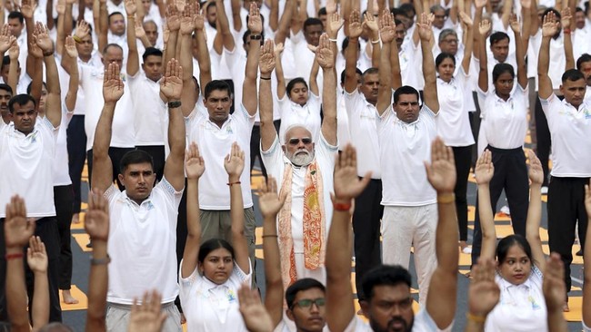 This handout photograph taken and released by the Indian Press Information Bureau (PIB) on June 21, 2026 shows India's Prime Minister Narendra Modi (C, front) participating in a yoga session on International Day of Yoga in Kolkata. (Photo by Indian P