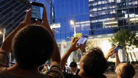 People point their mobile phones at CITIC Tower, also known as China Zun, where damage is visible on a high floor of the exterior, in Beijing, China June 26, 2026. REUTERS/Maxim Shemetov