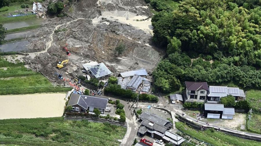 Petugas polisi dan tim penyelamat melakukan operasi pencarian dan pengamanan di sebuah rumah nan tertimbun tanah longsor akibat hujan lebat di Hirao, Prefektur Yamaguchi, Jepang, Sabtu (27/6/2026). (Kyodo/via REUTERS)
