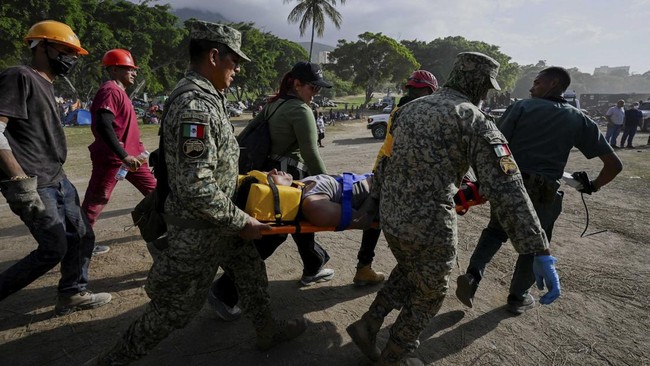Rescue personnel carry a young man on a stretcher, as rescue operations continue, after earthquakes hit the country, in La Guaira, Venezuela, June 27, 2026. REUTERS/Maxwell Briceno