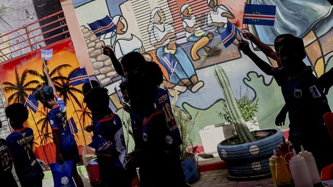 Children wave Cape Verde flags on a street ahead of the 2026 FIFA World Cup football match between Cape Verde and Saudi Arabia, in Praia, Cape Verde, June 26, 2026. REUTERS/Sodiq Adelakun