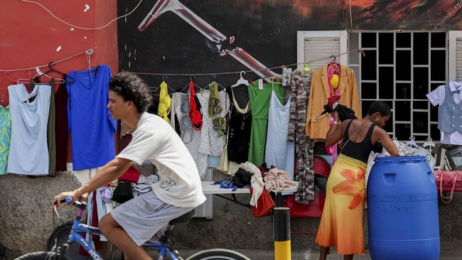 A street vendor displays her wares near a wall near a major road in Praia, Cape Verde, June 26, 2026. REUTERS/Sodiq Adelakun