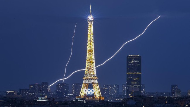 A lightning strike is seen close to the Eiffel Tower during the Paris 2024 Olympic Games in Paris on August 1, 2024. (Photo by Luis ROBAYO / AFP)