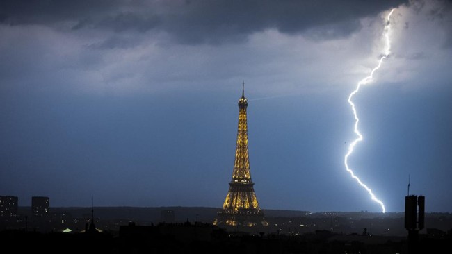 Lightning strikes during a storm near The Eiffel Tower in Paris late June 13, 2025. (Photo by Martin BUREAU / AFP)