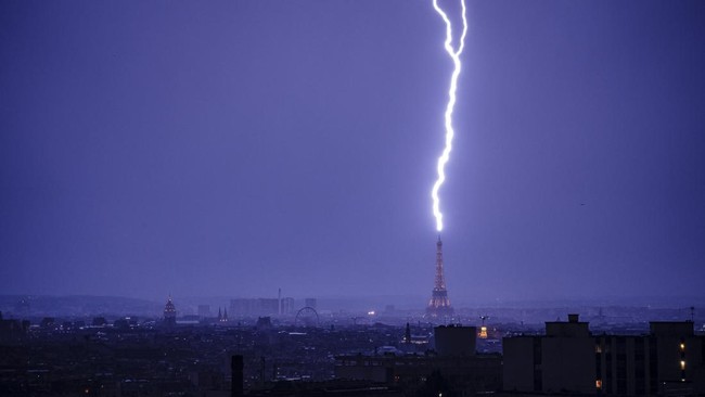 Lightning strikes the Eiffel Tower during a thunderstorm in Paris on June 27, 2026. (Photo by DIMITAR DILKOFF / AFP)