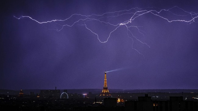 Lightning strikes over the Eiffel Tower during a thunderstorm in Paris on June 27, 2026. (Photo by DIMITAR DILKOFF / AFP)