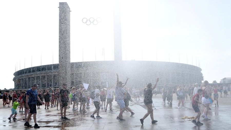 Orang-orang menikmati semprotan air dari meriam air polisi di depan stadion Olimpiade Olympiastadion selama gelombang panas nan sedang berjalan di Berlin, Jerman, 28 Juni 2026. (REUTERS/Maryam Majd)