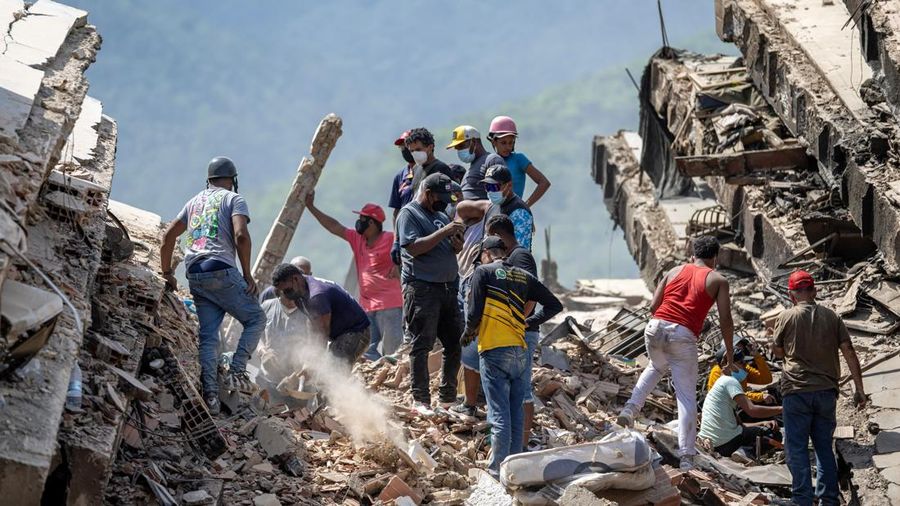 Para sukarelawan dan penduduk mencari korban selamat di reruntuhan gedung nan runtuh di Caraballeda, negara bagian La Guaira, Venezuela, pada 28 Juni 2026, setelah gempa bumi.