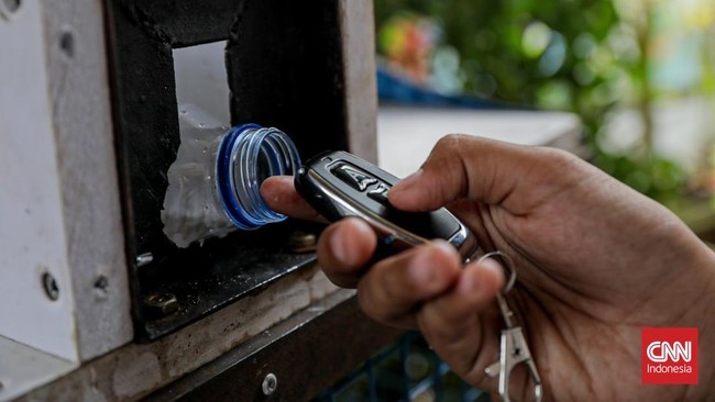 Warga menuangkan sampah sisa makanan ke dalam gerobak Komling untuk diolah menjadi kompos di Gandaria Utara, Kebayoran Baru, Jakarta, Senin (29/6). (CNN Indonesia/Febria Adha L).