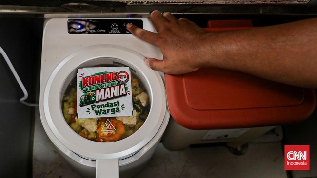 Warga menuangkan sampah sisa makanan ke dalam gerobak Komling untuk diolah menjadi kompos di Gandaria Utara, Kebayoran Baru, Jakarta, Senin (29/6). (CNN Indonesia/Febria Adha L).