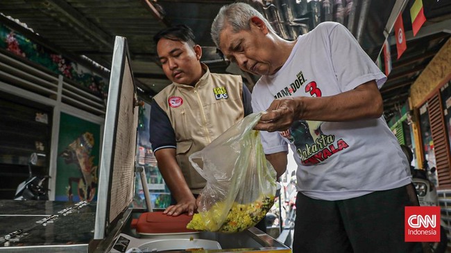 Warga menuangkan sampah sisa makanan ke dalam gerobak Komling untuk diolah menjadi kompos di Gandaria Utara, Kebayoran Baru, Jakarta, Senin (29/6). (CNN Indonesia/Febria Adha L).