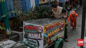 Warga menuangkan sampah sisa makanan ke dalam gerobak Komling untuk diolah menjadi kompos di Gandaria Utara, Kebayoran Baru, Jakarta, Senin (29/6). (CNN Indonesia/Febria Adha L).
