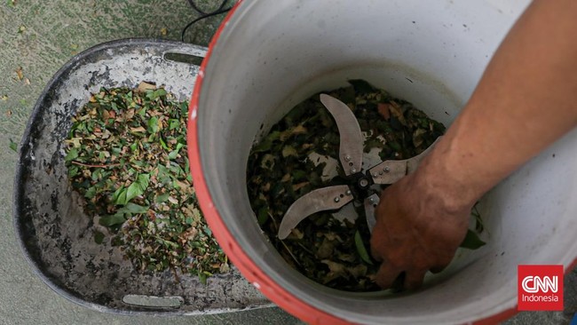 Warga menuangkan sampah sisa makanan ke dalam gerobak Komling untuk diolah menjadi kompos di Gandaria Utara, Kebayoran Baru, Jakarta, Senin (29/6). (CNN Indonesia/Febria Adha L).