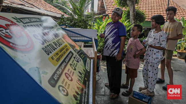 Warga menuangkan sampah sisa makanan ke dalam gerobak Komling untuk diolah menjadi kompos di Gandaria Utara, Kebayoran Baru, Jakarta, Senin (29/6). (CNN Indonesia/Febria Adha L).