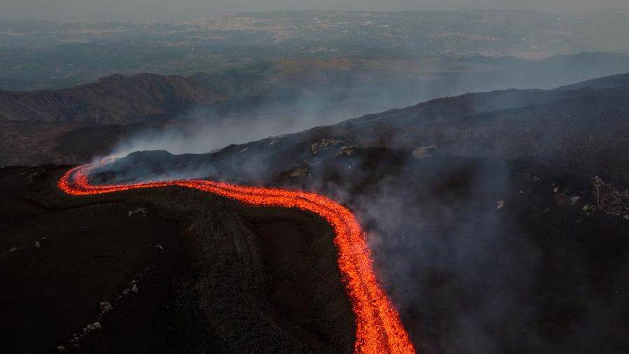 Aliran lava cair nan mengalir menuruni lereng Gunung Etna selama letusan, di Pulau Sisilia, Italia, Senin (29/6/2026). (REUTERS/Giuseppe Di Stefano)