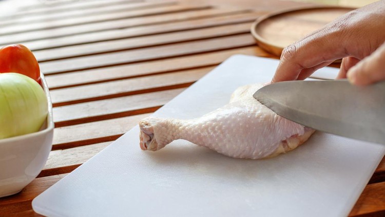 Chef cutting chicken for cooking
