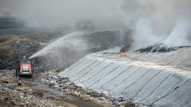 Petugas pemadam kebakaran berusaha memadamkan api di Tempat Pembuangan Akhir (TPA) Jatiwaringin, Kabupaten Tangerang, Banten, Selasa (30/6/2026). BPBD Kabupaten Tangerang mengerahkan sembilan unit mobil dan 45 personel untuk memadamkan kebakaran yang