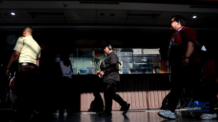 Pengemudi ojek online melintas di depan karangan bunga